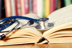 32398598-Ein-Stethoskop-ist-mit-einem-Buch-auf-dem-Schreibtisch-vor-B-cher-Lizenzfreie-Bilder